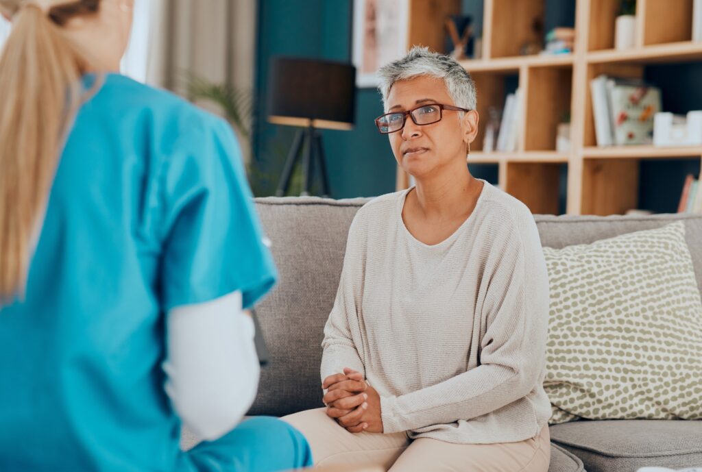 Nurse, senior woman and consultation on sofa in home for health check up or examination. Healthcare